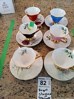 All six multicolour teacups with saucers displayed
