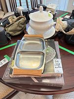 Lot overview showing porcelain tureen, stainless divided dish, boxed glass platter
