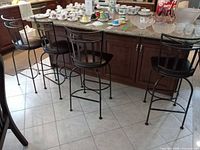 Four metal bar stools lined at kitchen island