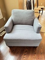 Front view of Superstyle light gray armchair showing overall design and condition