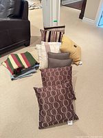 Group of pillows arranged on floor with folded crocheted blanket