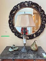 Lamp, ceramic pear, and ceramic base on marble-top table