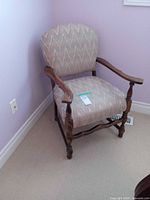 Full view of upholstered chevron armchair against wall