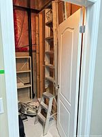 Both ladders folded and stored in narrow closet area