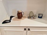 overall lot view showing loon decoy, pottery pieces and cup