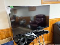 Front view of Samsung 40" TV on stand with accessories