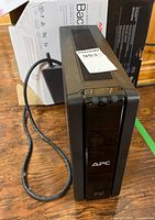 Front angled view of APC Back-UPS XS 1300 with power cord and box