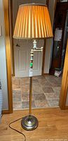 Full view of brass floor lamp with pleated shade
