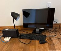Front view of monitor, lamp, UPS, keyboard, mouse, outlet extender and cables