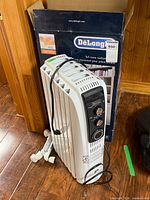Heater standing beside original box showing front and castors