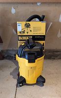 Vacuum with hose and wand in front of box