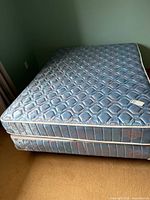 Mattress stacked on box spring showing overall condition and matching fabric