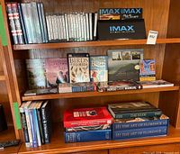 Full bookshelf showing DVDs on top shelf and books on middle and bottom shelves