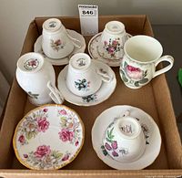 Box with assorted bone china cups and saucers