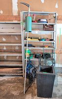 Full view of both metal shelving units, contents and woven planter