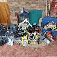 Wide view showing Makita miter saw, tool cases, drawer organizer, cutting mat, tote with cords