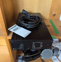 Front view showing brand, dual headphone jacks, volume knob, process-bypass toggle, power cable on top