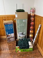 All boxed items, ornament cylinder, wrapping paper roll and boxed lights grouped together