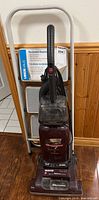 Hoover vacuum standing in front of folded stepladder