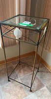 Full view of metal and glass side table showing shell inlay and frame