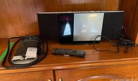 Stereo unit, remote and surge protector on shelf