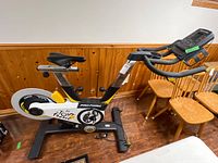 Side view of ProForm Le Tour de France bike showing frame, saddle, handlebars, console, and flywheel