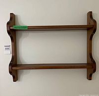 Front view of two-tier wooden shelf on wall