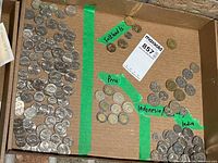 Tray with four taped sections of coins labelled by country