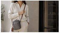 Model wearing grey nylon crossbody handbag with brown leather strap, showing size and appearance