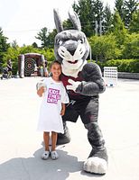 Team mascot posing with child at event