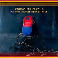 Front view marketing image of red-blue gradient Coleman Stranger Things cooler sling on forest stump