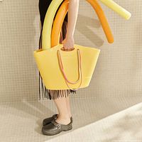 Model holding yellow Lemon Jelly tote with rope handles and pool noodles for scale