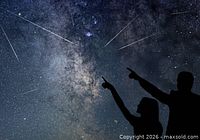 Composite image of night sky with silhouettes of two people pointing at meteor shower