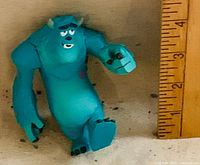 Front view of Sulley figurine beside ruler showing ~3 in height