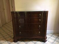 Front view of bombe dresser showing four curved drawers and glass top