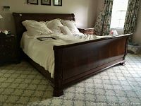 Overview shot showing entire sleigh bed frame with bedding