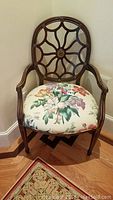 Front view of one chair showing open-work back and upholstered seat