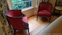 View of both chairs near a window on hardwood floor showing overall appearance, upholstery pattern and matching pair