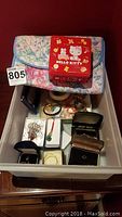 Top view of drawer with assortment of jewelry, boxes, and a floral patterned pouch