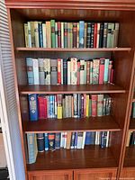 Full view of three shelves loaded with mixed books