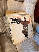Stack of vinyl LPs on chair, Fiddler on the Roof front, All-Star Hootenanny spine visible