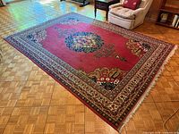 Full view of rug on floor showing pattern, colors and fringe