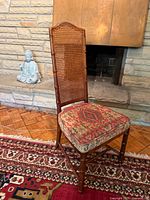 Front angled view of chair showing cane back and upholstered seat