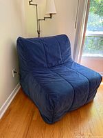 Front angled view of blue IKEA Lycksele chair-bed