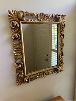 Front angled view showing ornate gilt frame and mirror glass