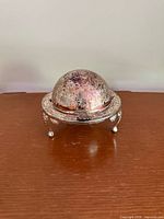 Front view of silver-plated domed serving dish showing overall form and feet