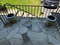 Both cast stone urn planters on porch