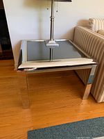 Front view of chrome and glass end table showing frame and glass top