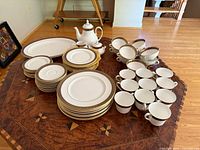 Full set arranged on table showing plates, cups, bowls, teapot, creamer, sugar, platter
