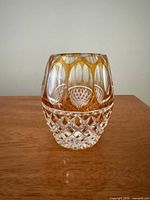 Front view of amber overlay crystal vase showing diamond cut lower section and oval window panels